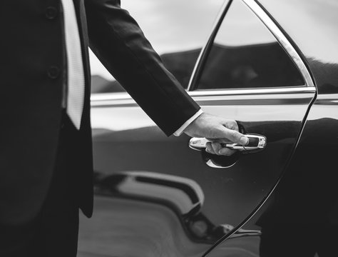 Chauffeur opening the door of a private car